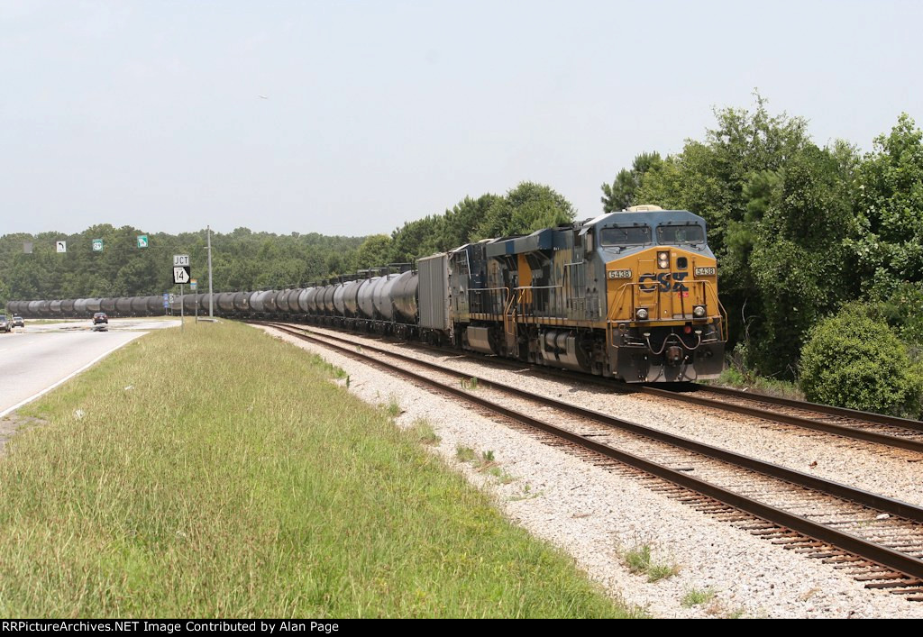 CSX 5438 and 5382 pause with a line of tank cars
